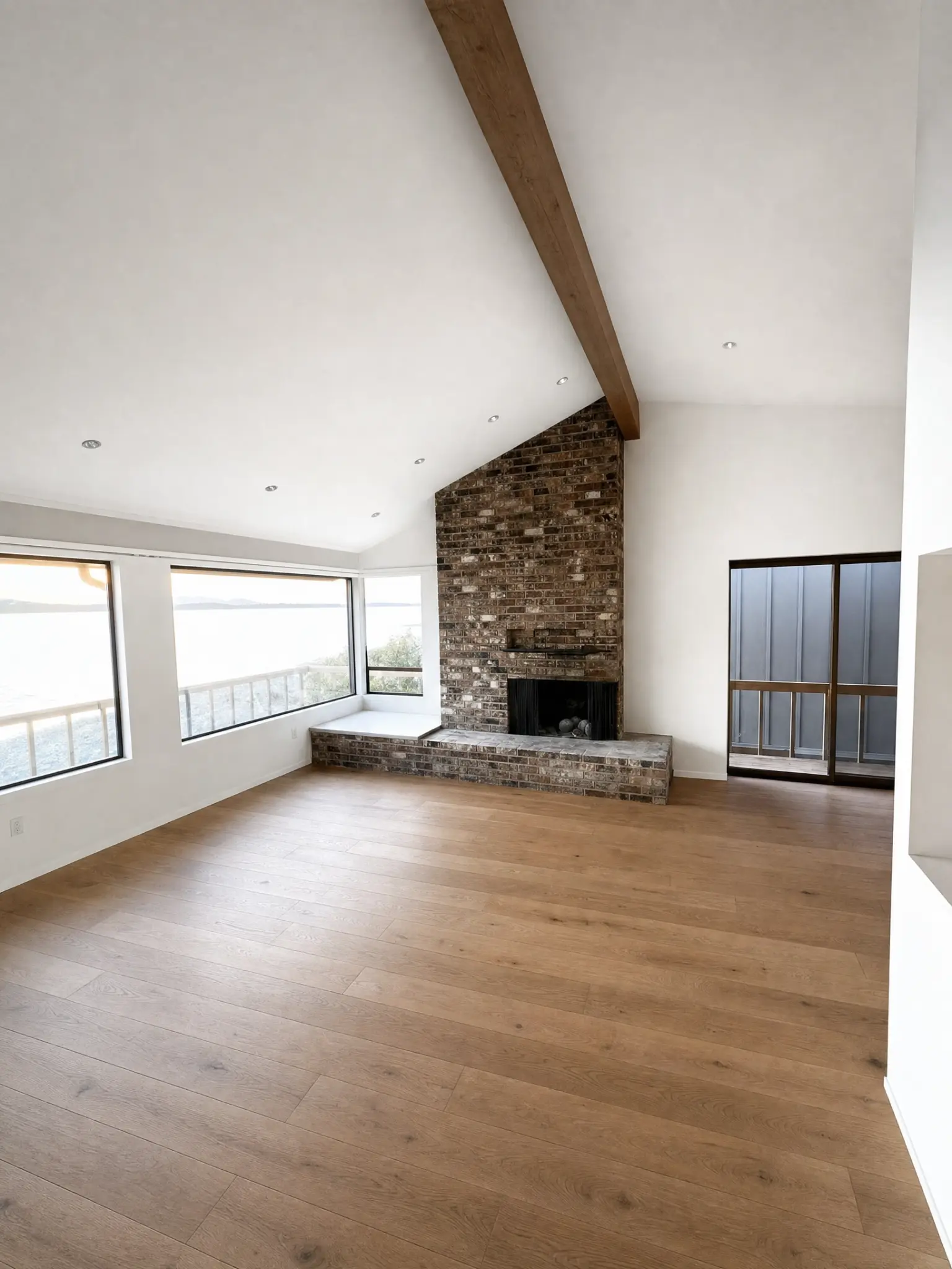 Vaulted ceiling and interior living room wall painting with exposed brick fireplace in Kirkland, WA