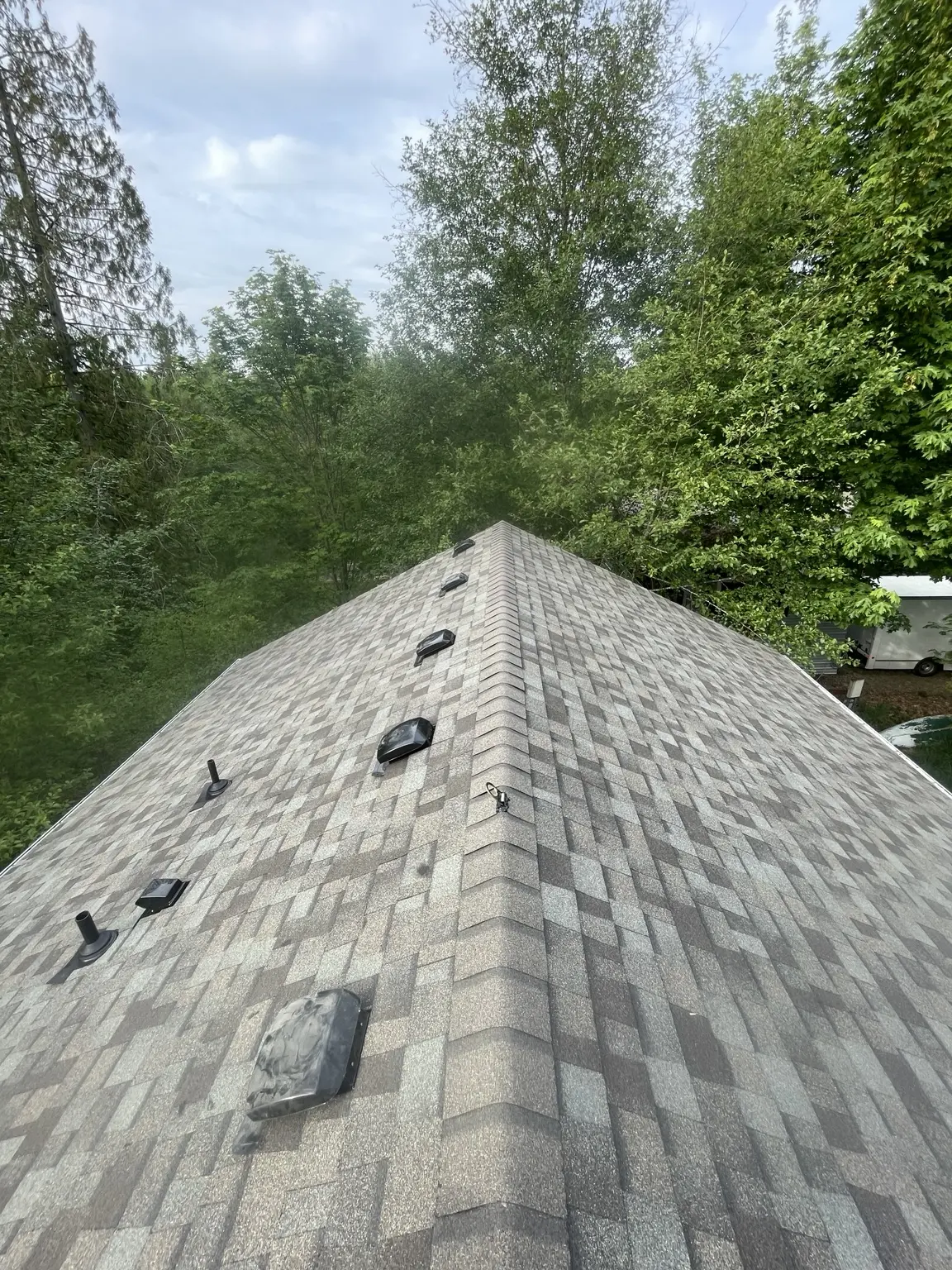 Completed gray architectural shingle roof with ridge caps and roof vents in Marysville, Washington